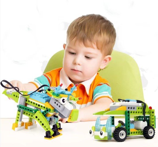 A young child enthusiastically building a LEGO robotics project with sensors and a motor, guided by an instructor.